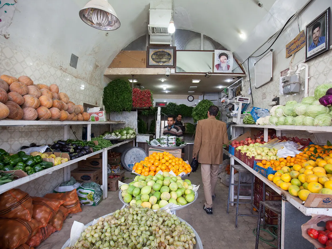 Les rayons d'une épicerie de quartier, fruits et légumes devant